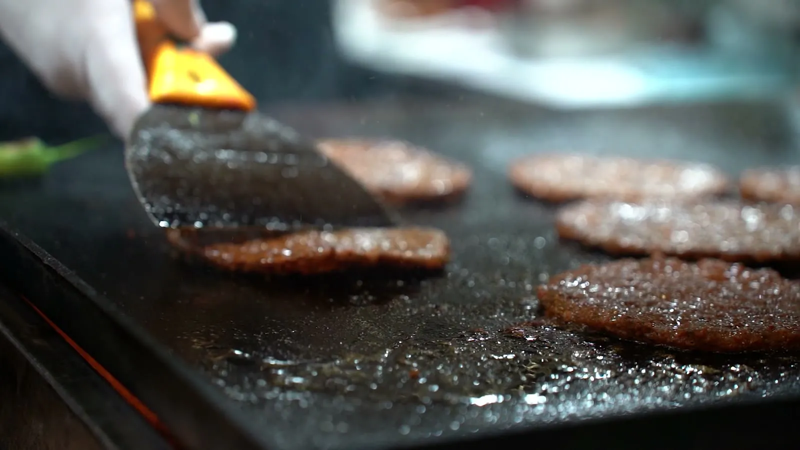 Burger patties cooking on a hot griddle