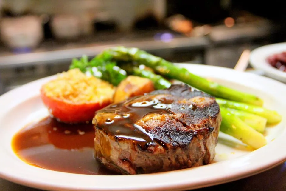 Carne asada plated with asparagus and roasted tomato
