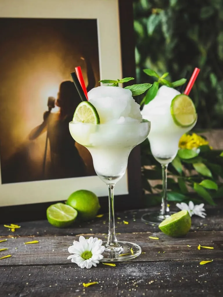 Two frozen margaritas with lime